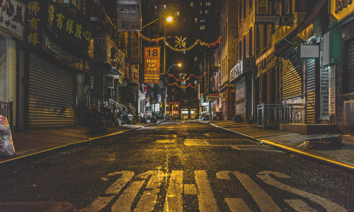 A street in New York shot from a crosswalk during night-time