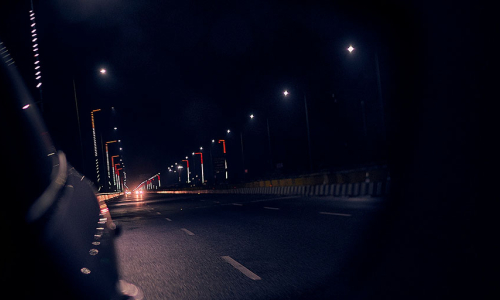 A street seen in a rear-view mirror, captured by the best Insta360 camera for car