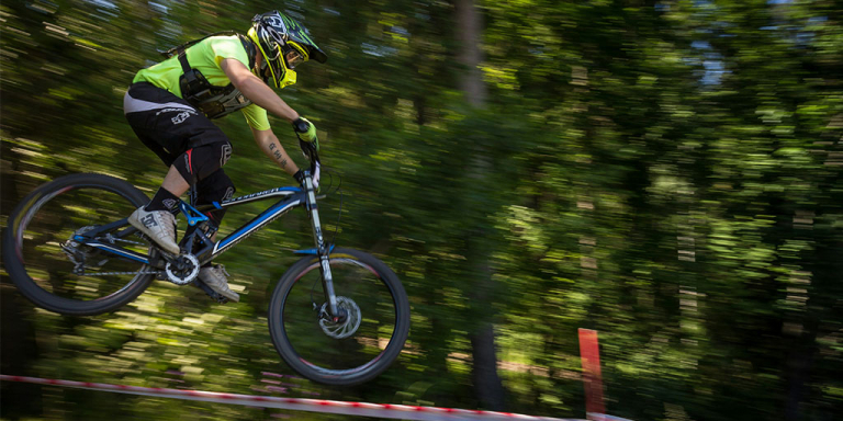 A man riding a mountainbike in a forest shot with the best action camera for action shots